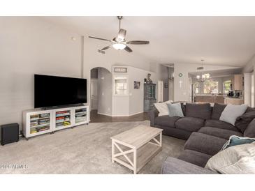 Spacious living room featuring a large sectional sofa, ceiling fan, and easy access to the kitchen area at 8319 E Portobello Ave, Mesa, AZ 85212
