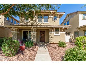 Charming two-story home with a welcoming front porch and drought-tolerant landscaping at 942 S Deerfield Ln, Gilbert, AZ 85296
