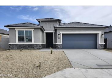 Charming single-story home with gray exterior, desert landscaping, and a two-car garage at 1584 S 241St Ave, Buckeye, AZ 85326