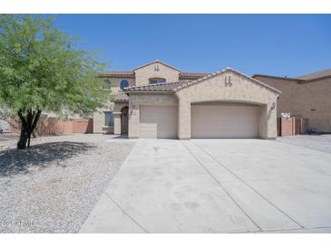 Lovely two-story home featuring an attached three-car garage and desert landscaping at 30268 W Sheila Ln, Buckeye, AZ 85396
