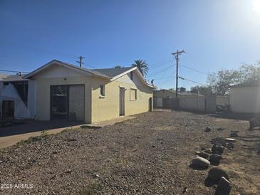 The gravel backyard features a block wall and small trees at 4304 N 55Th Dr, Phoenix, AZ 85031
