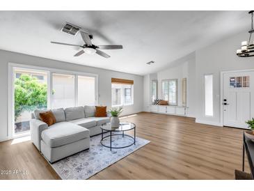 Bright living room with sliding glass doors and a comfortable gray sectional sofa with decorative pillows at 4344 W Kimberly Way, Glendale, AZ 85308