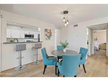 Inviting dining area with a modern pendant light, adjacent to the kitchen with bar stool seating at 154 W 5Th St # 246, Tempe, AZ 85281