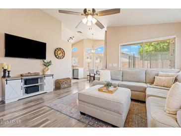 Inviting living room with a plush sectional sofa, light-toned walls and wood-style floors at 16586 W Latham St, Goodyear, AZ 85338