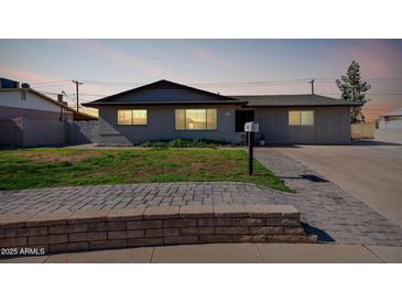 Charming single-story home featuring a well-manicured lawn and a paved walkway at 1747 W Devon --, Mesa, AZ 85201
