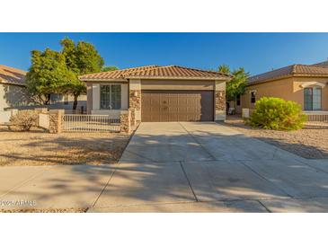 Charming single-story home featuring a tile roof, brown garage door, and low-maintenance landscaping at 20919 E Desert Hills Blvd, Queen Creek, AZ 85142