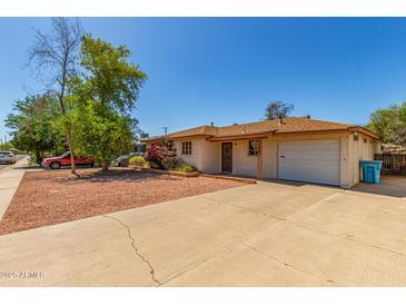 Charming single-story home with gravel yard and mature trees under a clear blue sky at 2138 W Northview Ave, Phoenix, AZ 85021