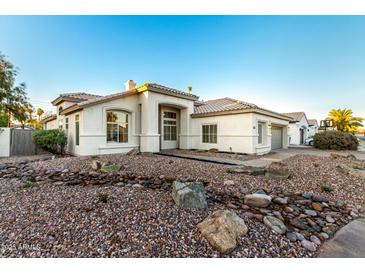 Charming single-story home with a well-manicured rock front yard and neutral color palette at 5426 E Karen Dr, Scottsdale, AZ 85254