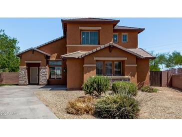 Inviting two-story home with a beautiful terracotta exterior and lovely desert landscaping at 833 S 113Th Ave, Avondale, AZ 85323