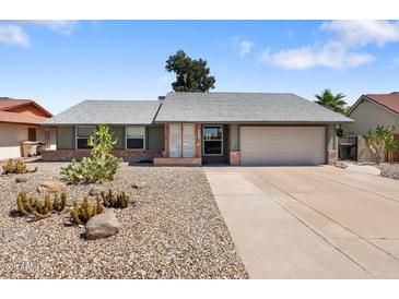 Single story home featuring desert landscaping, gray paint, brick accents, and a two car garage at 10410 W Royal Palm Rd --, Peoria, AZ 85345