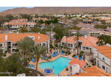 Beautiful aerial view of community pool, landscaping, and nearby neighborhood at 11375 E Sahuaro Dr # 2033, Scottsdale, AZ 85259