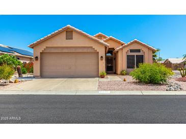 Charming single-story home with a desert landscape, tile roof, and a two-car garage at 11631 W Lemon Ct, Surprise, AZ 85378