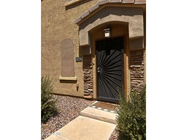 Stylish front door with a decorative sunburst design and stone accents for added curb appeal at 1350 S Greenfield Rd # 1221, Mesa, AZ 85206