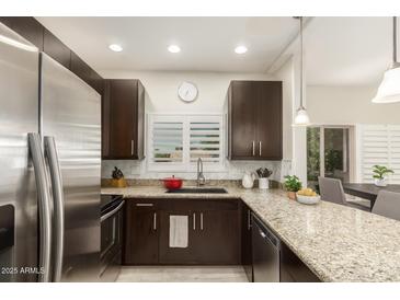 Modern kitchen features stainless steel appliances, granite countertops, and dark wood cabinetry at 14000 N 94Th St # 2187, Scottsdale, AZ 85260