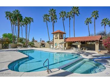 Stunning community pool and spa area, surrounded by lush landscaping and palm trees at 16648 N 30Th Ave, Phoenix, AZ 85053