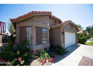 Charming single-story home with a well-maintained lawn and desert landscaping in front at 4527 E Amberwood Dr, Phoenix, AZ 85048