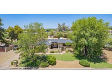 Charming single-story home featuring a well-manicured lawn and mature trees at 6330 E Delcoa Ave, Scottsdale, AZ 85254