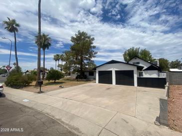 Charming home with a two-car garage, mature trees, and desert landscaping at 9053 N 53Rd Ave, Glendale, AZ 85302