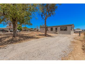 Well-maintained home featuring a clean gravel driveway, modern windows, and mature trees at 201 S 91St St, Mesa, AZ 85208