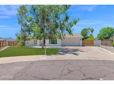 Charming single-story home featuring a well-maintained lawn, mature shade trees, and a two-car garage at 2607 E Mercer Ln, Phoenix, AZ 85028