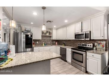 Bright kitchen featuring stainless steel appliances, granite countertops, and white cabinets at 2749 W San Juan Ave, Phoenix, AZ 85017