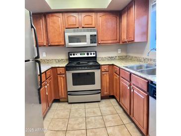 Well-lit kitchen featuring stainless steel appliances and ample countertop space at 3420 W Danbury Dr # C130, Phoenix, AZ 85053