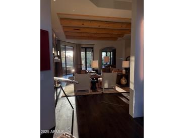 Elegant living room with hardwood floors, wooden beam ceiling and large windows with lots of natural light at 9894 N 79Th Pl, Scottsdale, AZ 85258