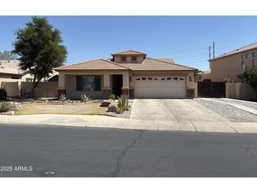 Charming single-story home with a well-manicured front yard and a two-car garage at 9911 W Riverside Ave, Tolleson, AZ 85353