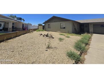 Modest single-story home featuring a low-maintenance gravel front yard at 14214 N 36Th Ave, Phoenix, AZ 85053