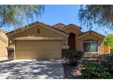 Inviting single-story home with a well-manicured front yard and attached two-car garage in a suburban neighborhood at 23682 W Bowker St, Buckeye, AZ 85326