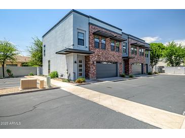 Modern townhome exterior boasts brick accents, private garages, and sleek architectural details at 240 W Missouri Ave # 1, Phoenix, AZ 85013