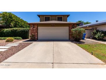 Charming home featuring a brick-accented garage and extended driveway at 3705 W Villa Theresa Dr, Glendale, AZ 85308