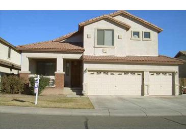Two-story home with three-car garage, well-maintained lawn and desert landscaping at 11210 W Alvarado Rd, Avondale, AZ 85392