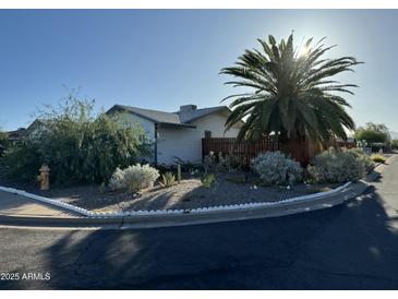 Quaint single story home with desert landscaping, a fire hydrant, and mature palm tree on a sunny day at 433 S 113Th Pl, Mesa, AZ 85208