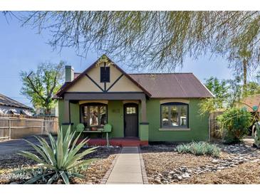 Charming home with a rust-colored corrugated metal roof, green painted brick, and a well-manicured front yard at 1813 E Willetta St, Phoenix, AZ 85006
