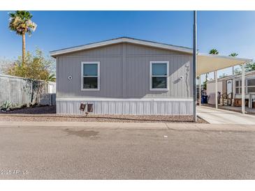 Charming single-story home with gray siding and carport on a sunny day at 2060 N Center St # 133, Mesa, AZ 85201