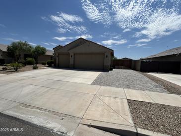 Charming single-story home featuring a wide driveway and three-car garage at 22325 N 185Th Ave, Surprise, AZ 85387