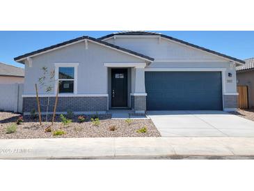 Charming single-story home showcasing a blue garage door and professionally landscaped front yard at 3805 N Camden Dr, Florence, AZ 85132