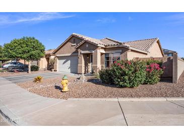 Charming single-story home featuring desert landscaping, a tile roof, and a two-car garage at 671 W Jahns Ct, Casa Grande, AZ 85122