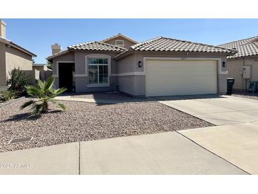 Charming single-story home with desert landscaping, tile roof, and attached two-car garage at 8673 W Palm Ln, Phoenix, AZ 85037