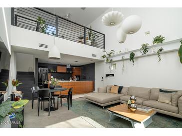 Open-concept living room featuring modern lighting, sleek black accents, and a cozy seating area with decorative plants at 1111 W University Dr # 1017, Tempe, AZ 85281