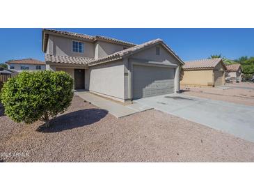 Inviting home featuring a neutral color palette, tile roof, attached garage, and low maintenance desert landscaping at 12813 W Paradise Dr, El Mirage, AZ 85335