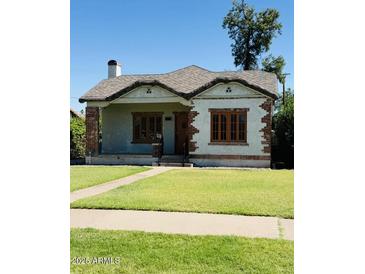 Charming single-story home featuring brick accents, a well-maintained lawn, and a classic architectural style at 1625 W Vernon Ave, Phoenix, AZ 85007