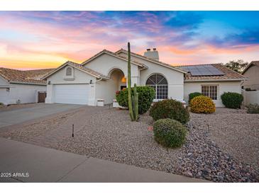 Charming single-story home with a well-manicured front yard and solar panels on the roof at 16426 N 49Th St, Scottsdale, AZ 85254