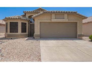 Inviting single-story home featuring a well-maintained yard and two-car garage, perfect for comfortable living at 15131 W Melissa Ln, Surprise, AZ 85374