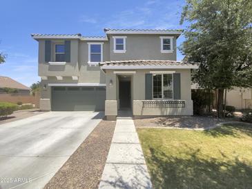 Charming two-story home featuring a well-maintained lawn, a two car garage, and a welcoming covered porch at 21262 E Cherrywood Dr, Queen Creek, AZ 85142