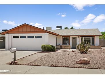 Charming single-story home with desert landscaping, a two-car garage and mature cacti at 2745 E Dahlia Dr, Phoenix, AZ 85032