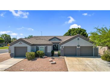 Charming single-story home featuring a tile roof, three-car garage, and inviting desert landscaping at 5529 E Holmes Ave, Mesa, AZ 85206