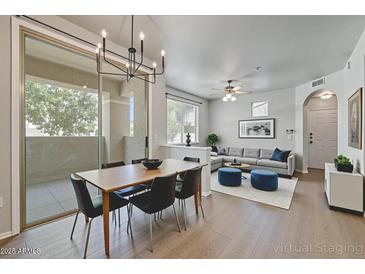Bright living room featuring wood floors, a dining table, and a comfortable sofa at 29606 N Tatum N Blvd # 265, Cave Creek, AZ 85331