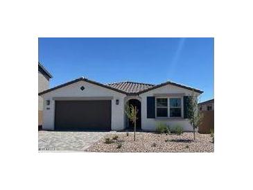 Charming single-story home with a well-manicured front yard and a two-car garage, under a clear blue sky at 5027 W Hardtack Trl, Laveen, AZ 85339